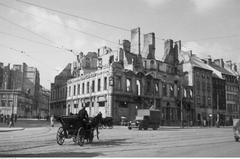 Destroyed tenement house at the corner of Miodowa Street and Krakowskie Przedmieście with a horse-drawn carriage visible