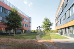 Masaryk University campus buildings with green trees and clear blue sky