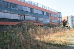 Masaryk University campus with modern buildings and green trees under a cloudy sky