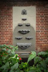 Blue slate wall fountain with water cascading through seven shells in Benjamin Rush Garden