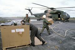 Colonel Bruce M. Durvine and 55th Aerospace Rescue and Recovery Squadron members carrying plastic boxes at Jonestown base in Guyana