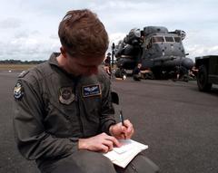 U.S. Air Force C-5 Galaxy co-pilot filling flight plans while MH-53J Pave Low helicopter is unloaded at Libreville International Airport in Gabon