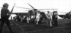 Evacuees from Vietnam on flight deck of USS Midway aircraft carrier during Operation Frequent Wind with HH-53 Super Jolly Green Giant helicopter in background