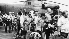 Vietnam War evacuees on USS Midway flight deck with HH-53 Super Jolly Green Giant helicopter in background