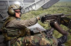 MH-53 Pave Low tail gunner sitting on aircraft ramp during low-level training mission over Florida
