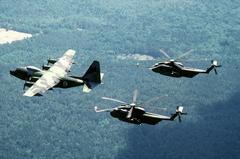 Two U.S. Air Force Sikorsky HH-53C Super Jolly Green Giant helicopters refueling mid-air from Lockheed HC-130P Hercules aircraft