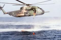 U.S. Air Force Sikorsky HH-53C Super Jolly Green Giant helicopter dropping a litter to pararescuemen during sea rescue exercise