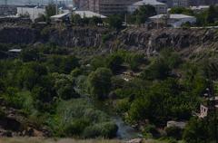 Hrazdan River flowing through lush greenery under a cloudy sky