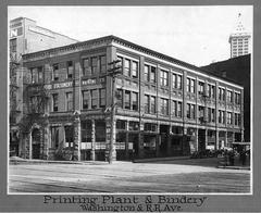 Exterior of Lowman and Hanford Printing and Binding building in Seattle circa 1914, with Smith Tower visible in background and delivery wagon on street