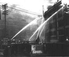 Firefighters aiming hoses at fire on Grand Trunk Pacific Dock in Seattle, July 30, 1914