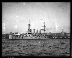 Armored cruiser Seattle anchored in Elliott Bay with Seattle skyline in the background, 1920s