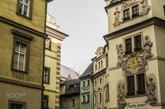 Charles Bridge in Prague over the Vltava River with historic buildings and cloudy sky