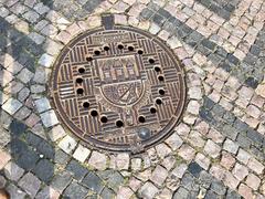 Detailed manhole cover with intricate patterns in Staré Zámecké Schody, Hradčany, Prague, Czech Republic