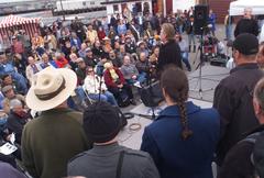 Crowd sitting on chairs listening to a musician at Hyde Street Pier