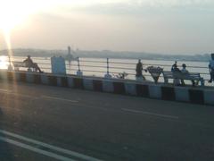 People resting by the Tank Bund in Hyderabad during sunset