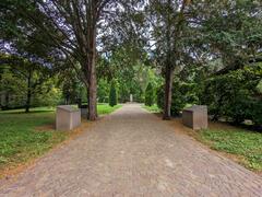 Andreas Hofer Park in Mantua with lush green trees and benches