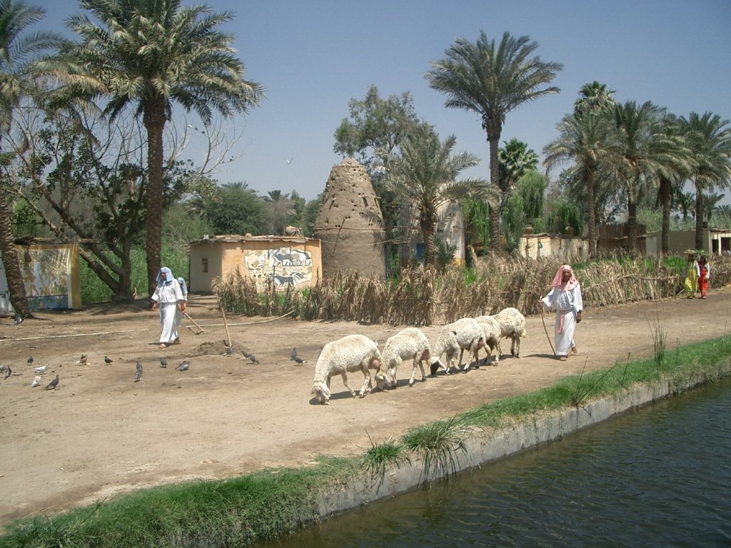 Scenic view of the Pharaonic Village with a traditional boat in the water and ancient Egyptian architecture