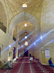 Interior of al-Sarai Mosque with red prayer carpets, large columns and arches in old Baghdad, Iraq