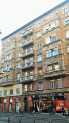 Street view of Népszínház utca with buildings and vehicles