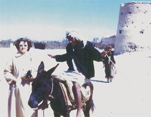 Colleen posing in front of Qatif Castle in 1953 with a local villager making a funny face