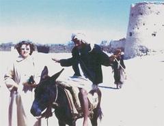 Colleen posing in front of Qatif Castle in 1953 with a local villager making a funny face