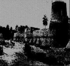 Old photo of Qatif Castle showing plaster and mud burning work in front of the castle