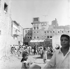 View of one of the courtyards inside Qatif Castle showing residential clusters and commercial shops in 1972