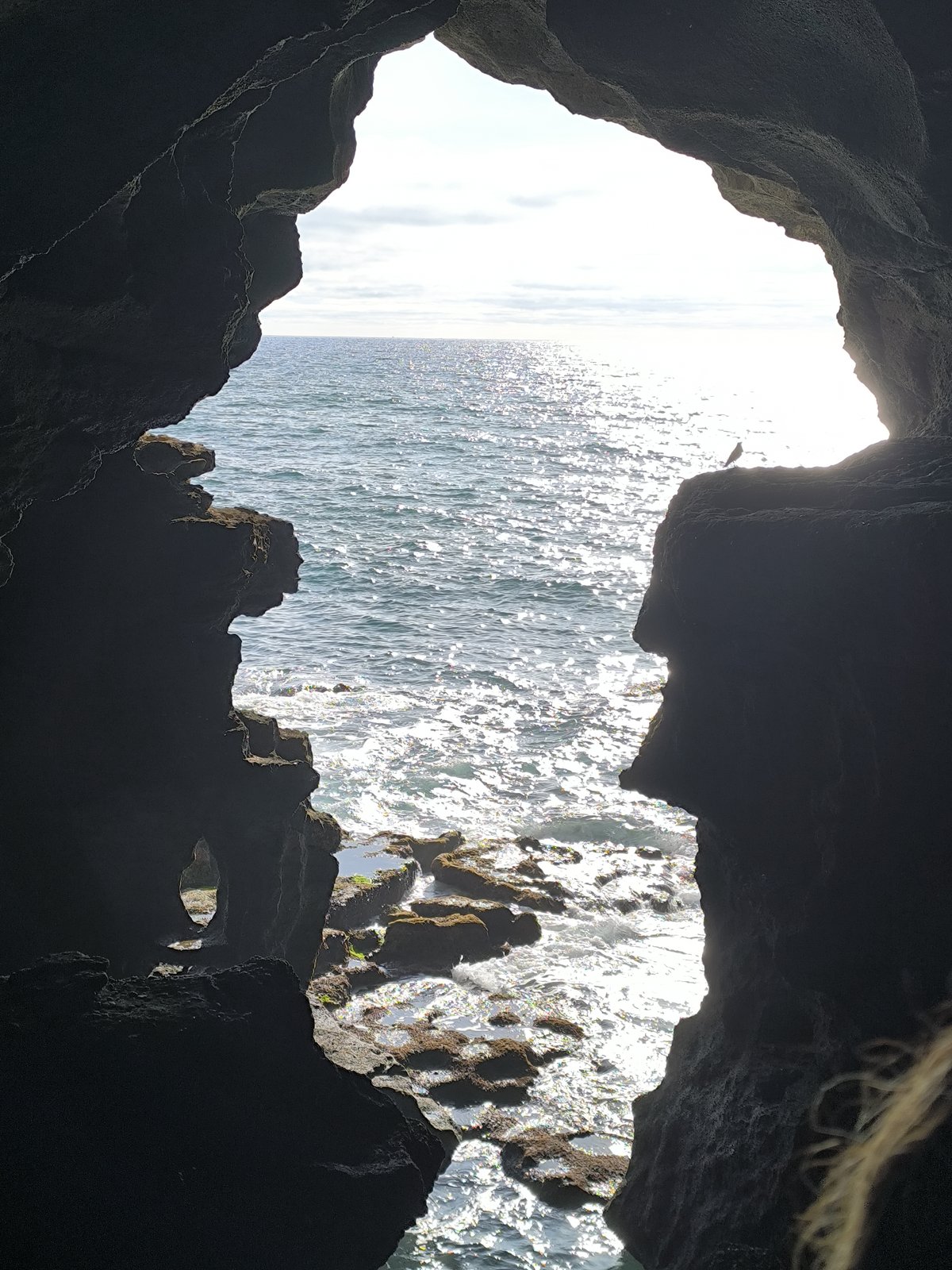 Entrance of Hercules Cave with rocky arch and blue sea in Morocco