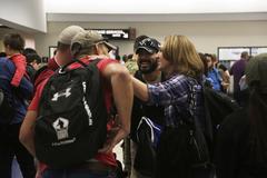 U.S. Army active duty soldiers and veterans greet each other while waiting to gather luggage at El Paso International Airport