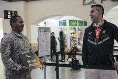 U.S. Army Spc. Jonathan Bryant greeting U.S. Army veteran Sgt. Robbie Gaupp at El Paso International Airport for Army Trials 2015