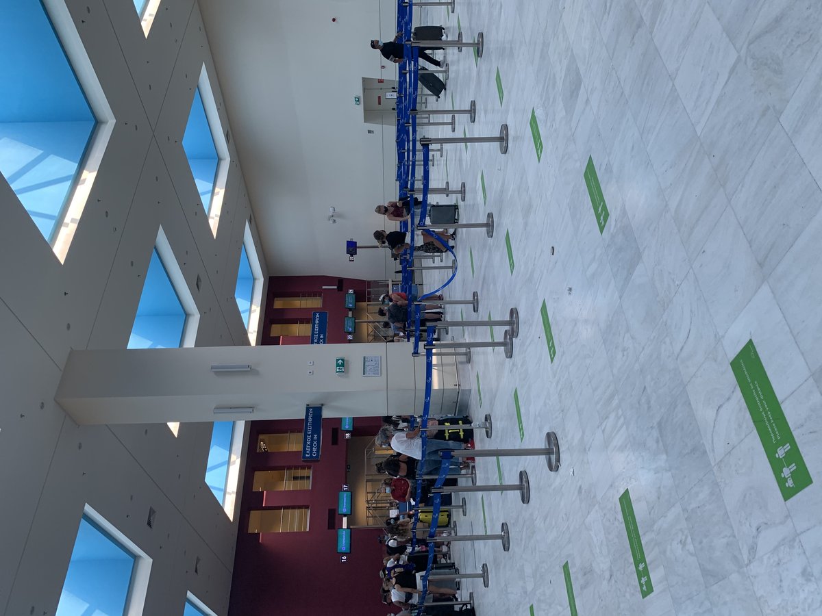 Check-in counters at La Canée Airport with passengers and staff in July 2021