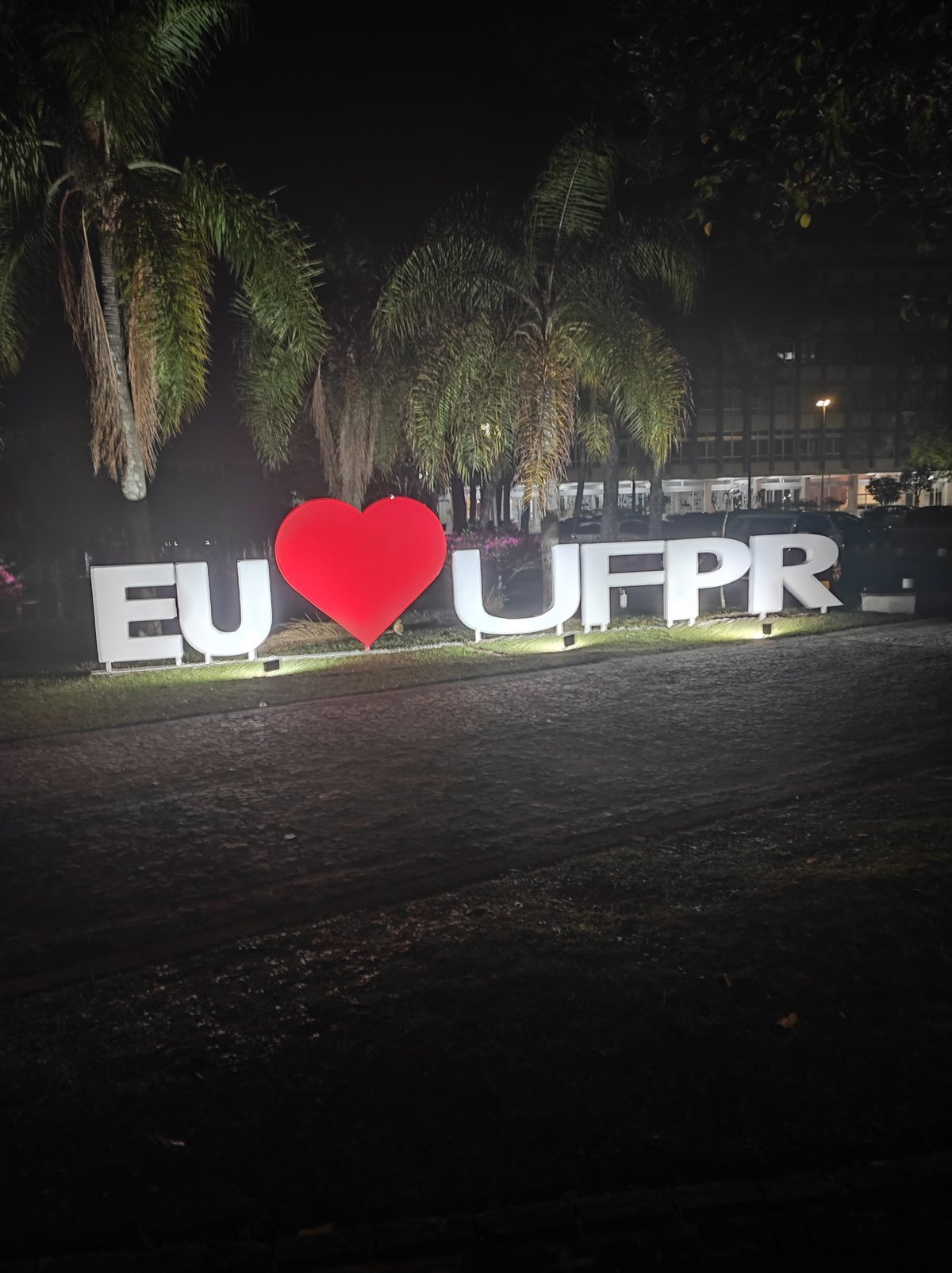 Eu amo UFPR graffiti on Centro Politécnico building at night
