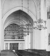 Interior view of Västerås Cathedral with high vaulted ceilings and rows of wooden pews