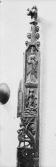 Carved oak bench end showing relief sculptures of branchwork with leaves, rose-like flowers, coats of arms and helmets, Samson and the lion, Madonna with child and a kneeling praying man, gilded and painted, early 15th century