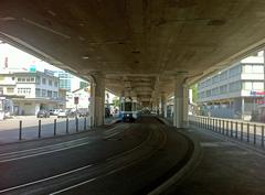 Tram stop Schiffsbau under Hardbrücke bridge in Zürich with tram approaching