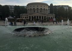 Bassin de la Villette fountain in Paris with water jets and buildings in the background