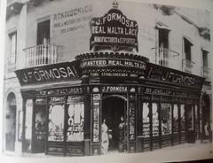J. Formosa's historic Strada Reale street in Valletta, Malta with classic architecture under clear sky