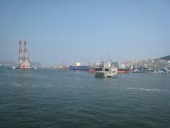 Busan ferry terminal with multiple docks and ferries under a clear sky
