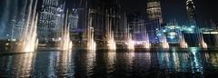 Dubai Fountain show at nighttime with city lights