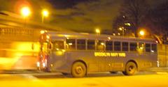 Night view of northbound Brooklyn Navy Yard bus passing plaza beneath Manhattan Bridge over Jay Street, Brooklyn