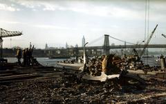 Burned-out aircraft engine and debris on damaged flight deck of USS Franklin aircraft carrier with Manhattan skyline in background