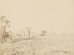 View of the ruins at Karnak Temple with palm trees by John Beasly Greene