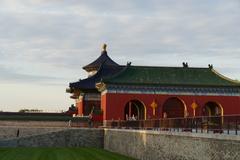 Gate of Temple of Heaven in Beijing surrounded by trees under a cloudy sky