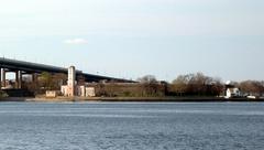 View of Fort Schuyler across East River from Little Bay Park on a mostly cloudy afternoon