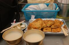 Korean mung bean pancakes (Bindaetteok) with marinated onions and rice wine (Makgeolli) at Gwangjang Market