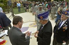Deputy Secretary of Defense Ashton B. Carter signing Purple Heart ceremony program at Brook Army Medical Center