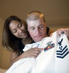 Petty Officer 1st Class Michael Lammey and his wife looking at his Navy ribbons at Brook Army Medical Center