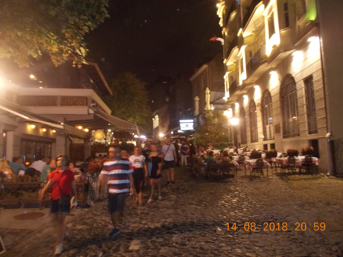 Skadarlija Bohemian Quarter in Belgrade at night with busy cobblestone street full of tourists and restaurant queues