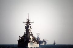 A bow view of the battleship USS Wisconsin (BB-64) leading the amphibious assault ship USS Tripoli (LPH-10) and other vessels on patrol in the Gulf of Oman