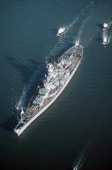 Tug boats assisting battleship USS Wisconsin BB 64 out to sea before sea trials on 8/30/1988